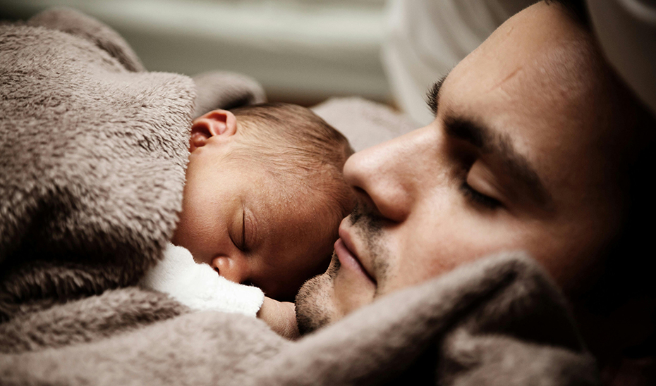 
			      Un padre descansa junto a su hijo.			    
			  